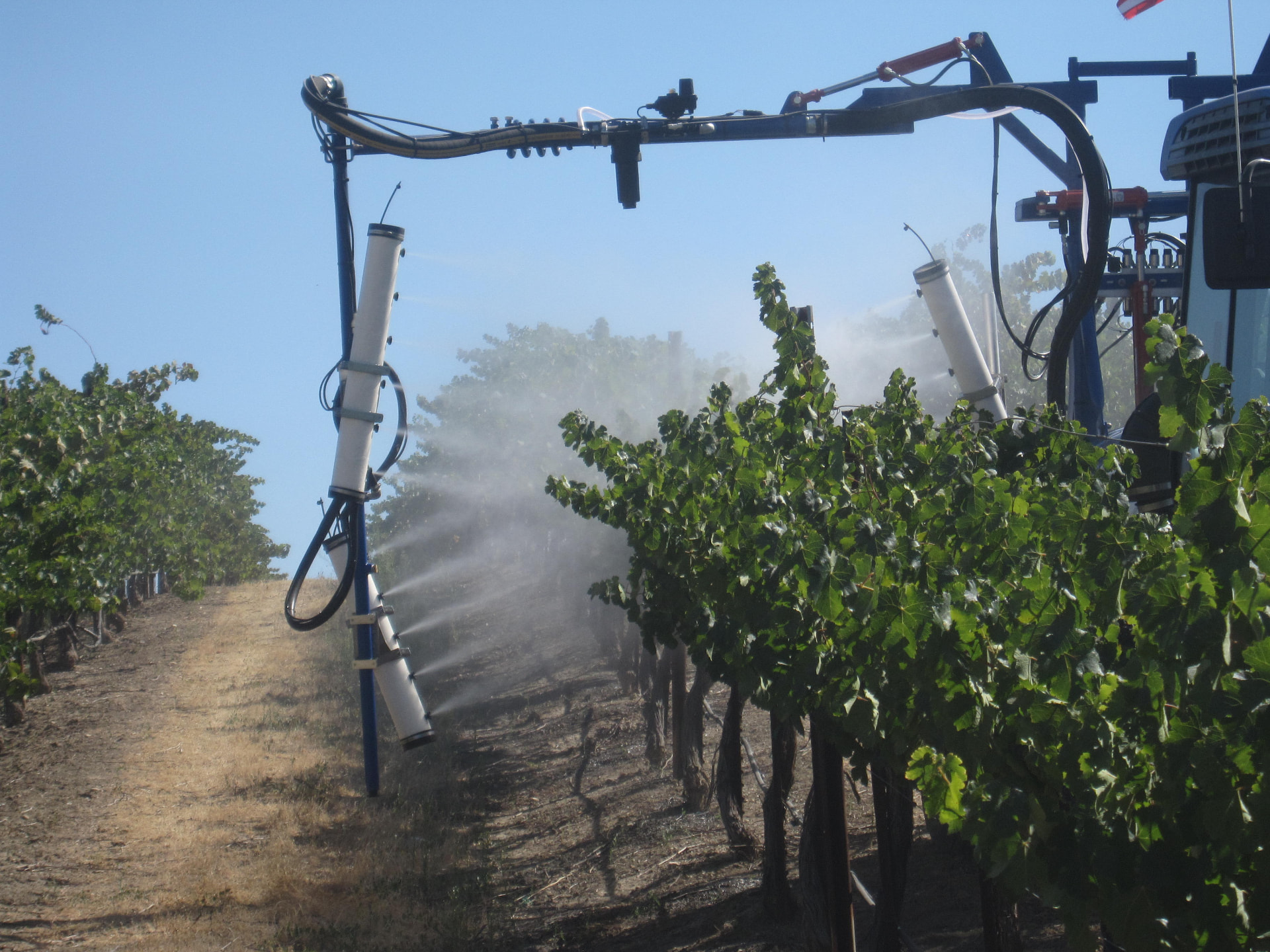Close-up of OnTarget nozzle towers spraying a vineyard canopy