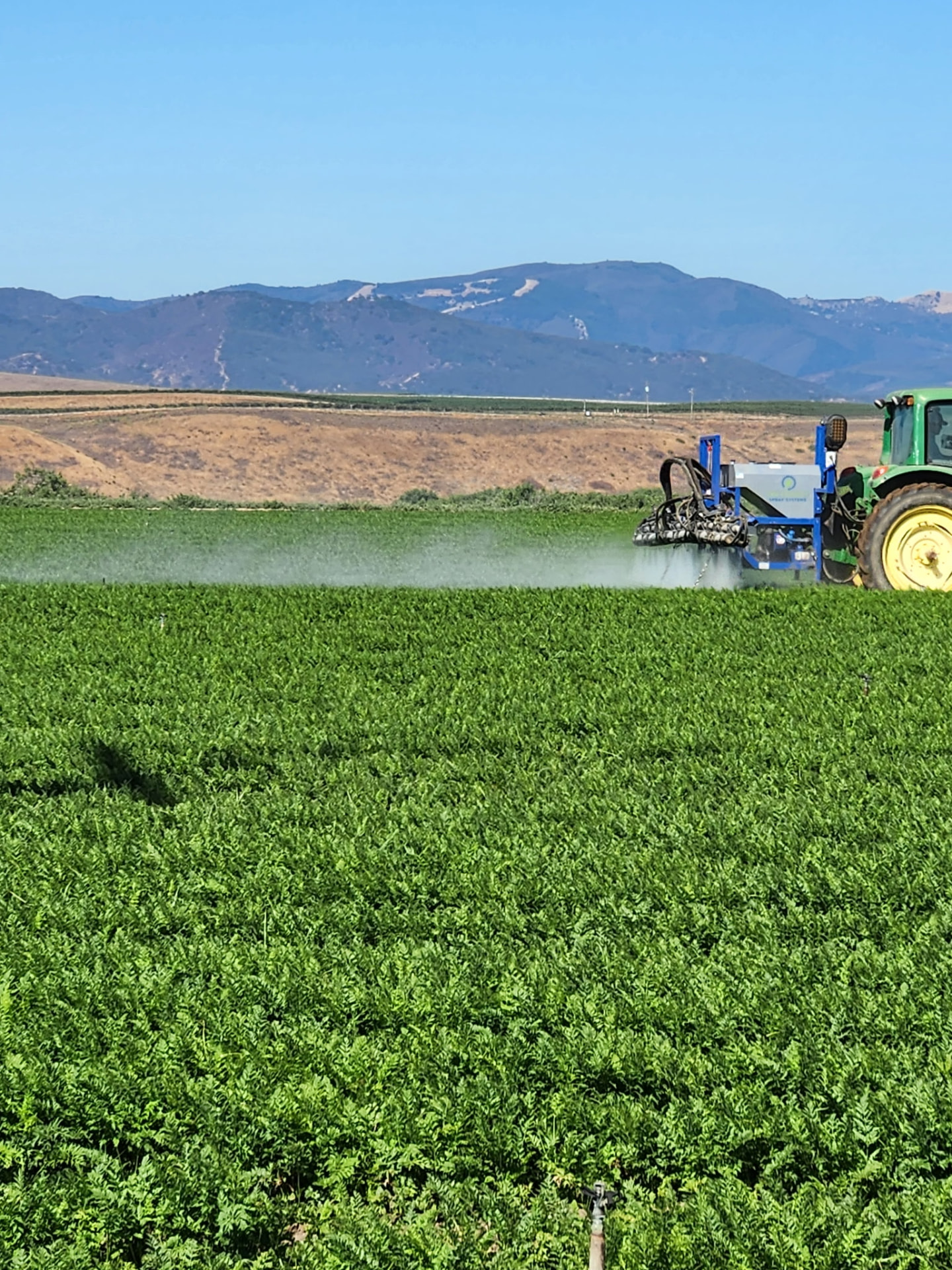 OnTarget field boom sprayer treating a vegetable row crop field